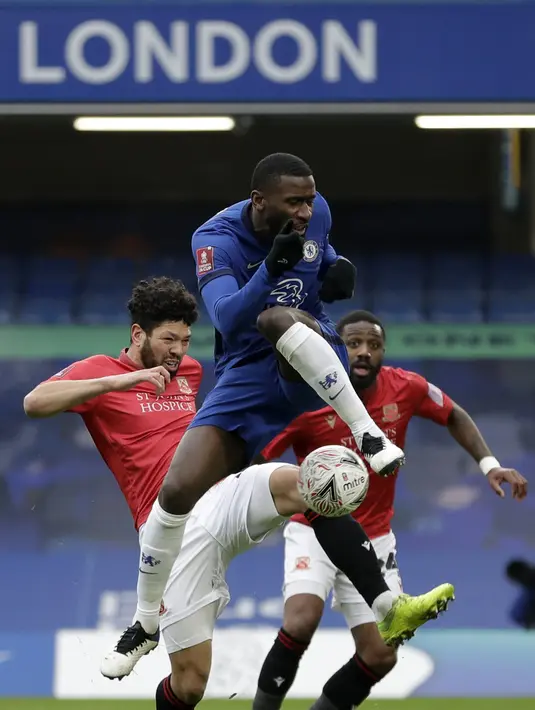 Bek Chelsea, Antonio Rudiger berebut bola dengan gelandang Morecambe tim divisi empat Morecambe, Nathaniel Knight-Percival pada babak ketiga Piala FA 2020/21 di Stamford Bridge, Minggu (10/1/2021). Chelsea menggasak Morecambe dengan skor telak 4-0. (AP Photo/Matt Dunham)