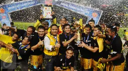 Pemain tengah Mitra Kukar, Riski Pelu (keempat kanan) memegang piala usai mengalahkan Semen Padang di final turnamen Piala Jenderal Sudirman, Minggu (24/1/2016). Mitra Kukar unggul 2-1 atas Semen Padang. (Liputan6.com/Helmi Fithriansyah)