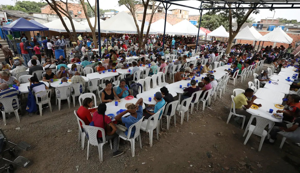 Pengungsi Venezuela makan siang di tempat penampungan Divina Providencia, La Parada, Cucuta, Kolombia, Senin (18/2). Tempat penampungan ini menyiapkan makanan kecuali hari Minggu. (AP Photo/Fernando Vergara)
