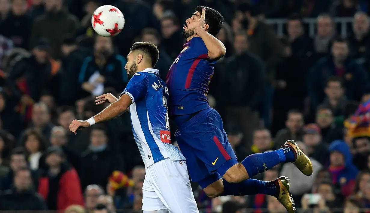 Pemain Barcelona Luis Suarez berebut bola dengan bek Spanyol Espanyol Marc Navarro pada laga leg kedua perempat final Copa del Rey di Camp Nou, Kamis (25/1). Barcelona memetik kemenangan dua gol tanpa balas atas lawannya. (AFP PHOTO/LLUIS GENE)