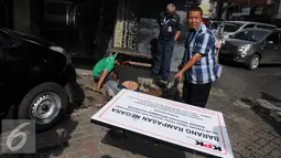 Pekerja menggali lubang untuk memasang plang segel ruko Nazaruddin yang berada di Wijaya Grand Center, Jakarta Selatan, Senin (28/11). Ruko ini berada di blok C 15-16, yang sebelumnya dijadikan kantor penjualan alat kesehatan. (Liputan6.com/Helmi Affandi)