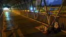 Seorang pria tunawisma tidur di jembatan selama penguncian atau lockdown nasional yang diberlakukan di Kolombo, Sri Lanka, Senin (23/8/2021).  Pemerintah Sri Lanka menerapkan lockdown selama 10 hari ketika kasus corona Covid-19 kembali meningkat. (Ishara S. KODIKARA / AFP)