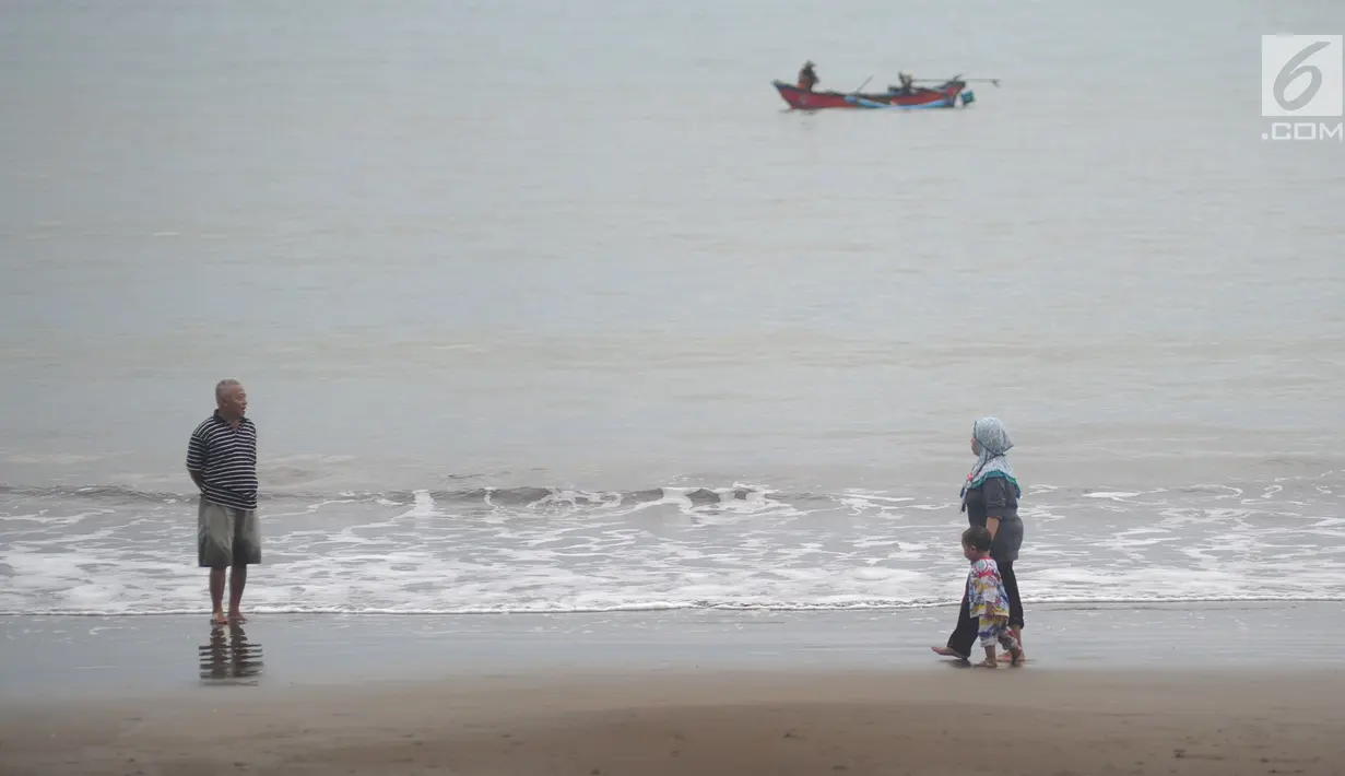 Wisatawan menikmati pemandangan Pantai Palangpang di Kecamatan Ciemas, Kabupaten Sukabumi, Selasa (26/6). Pantai Palangpang atau yang biasa disebut Teluk Ciletuh berada di titik utama Geopark Ciletuh-Palabuhanratu. (Merdeka.com/Arie Basuki)