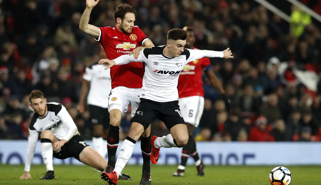 Bek Manchester United, Daley Blind (tengah) berebut bola dengan pemain Derby County, Tom Lawrence pada laga PIala FA di Old Trafford, Manchester, (5/1/2018). Manchester United menang 2-0. (Martin Rickett/PA via AP)