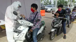 Pengendara motor mengikuti rapid test Covid-19 gratis di danau Asya Jakarta Garden City, Jakarta Timur, Kamis (28/5/2020). Perumahan Asya memberikan layanan rapid test sebagai upaya membantu pemerintah dalam menekan penyebaran Covid-19 dengan konsep drive thru. (Liputan6.com/Fery Pradolo)