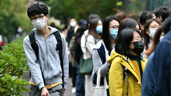 Anggota staf Otoritas Rumah Sakit Hong Kong mengantre menandatangani surat petisi pemogokan kerja saat memprotes penutupan penyeberangan perbatasan dari China di Hong Kong (4/2/2020). Hong Kong pada 4 Februari melaporkan kematian pasien karena virus corona. (AFP/Anthony Wallace)