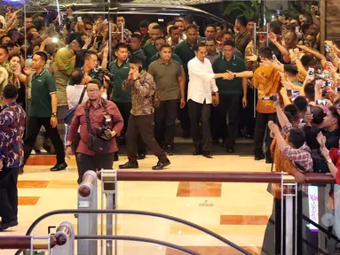 Presiden Joko Widodo menyapa warga ketika tiba di Sun Plaza Medan, Sumatera Utara, Jumat (24/11). Jokowi tiba mengenakan kemeja putih lengan panjang dan celana hitamnya sambil menebar senyum. (Liputan6.com/Johan Tallo)