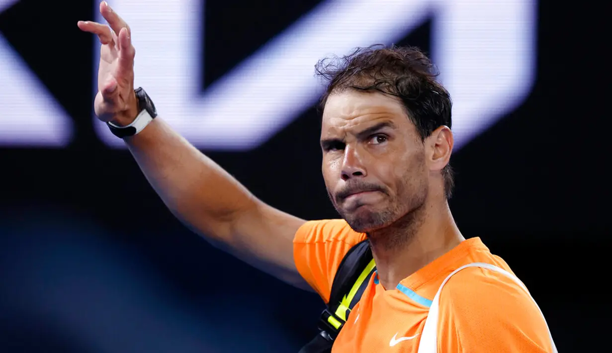 Petenis Spanyol Rafael Nadal melambaikan tangan saat meninggalkan Rod Laver Arena menyusul kekalahannya atas petenis Amerika Serikat Mackenzie McDonald pada putaran kedua kejuaraan tenis Australian Open di Melbourne, Australia, Rabu (18/1/2023). Rafael Nadal harus tersingkir dari Australian Open 2023 setelah ia mengalami cedera dan kemudian takluk 4-6, 4-6, 5-7 dari petenis Amerika Serikat MacKenzie McDonald. (AP Photo/Asanka Brendon Ratnayake)