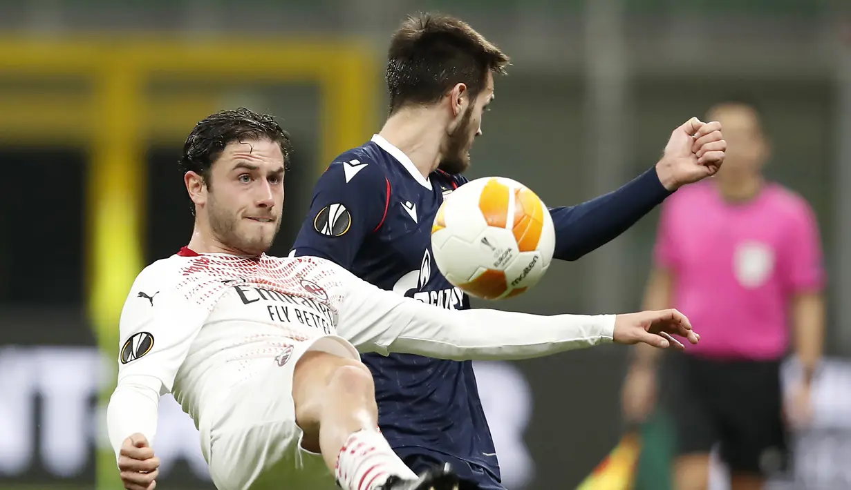 Bek AC Milan, Davide Calabria (kiri) berebut bola dengan gelandang Red Star Belgrade, Mirko Ivanic dalam laga leg kedua babak 32 Besar Liga Europa 2020/21 di San Siro Stadium, Kamis (25/2/2021). AC Milan bermain Imbang 1-1 dengan Red Star Belgrade. (AP/Antonio Calanni)
