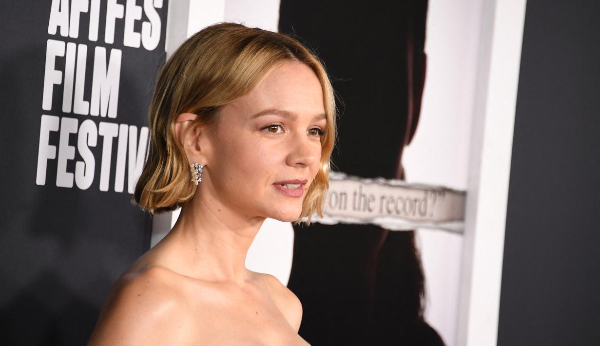 Carey Mulligan berpose saat menghadiri AFI Fest 2022: Red Carpet Premiere “She Said” di TCL Chinese Theatre di Hollywood, California pada 4 November 2022.. Carey menyelipkan poni di belakang telinganya untuk memamerkan anting-anting berliannya yang menjuntai. (Jesse Grant/Getty Images for AFI/AFP)