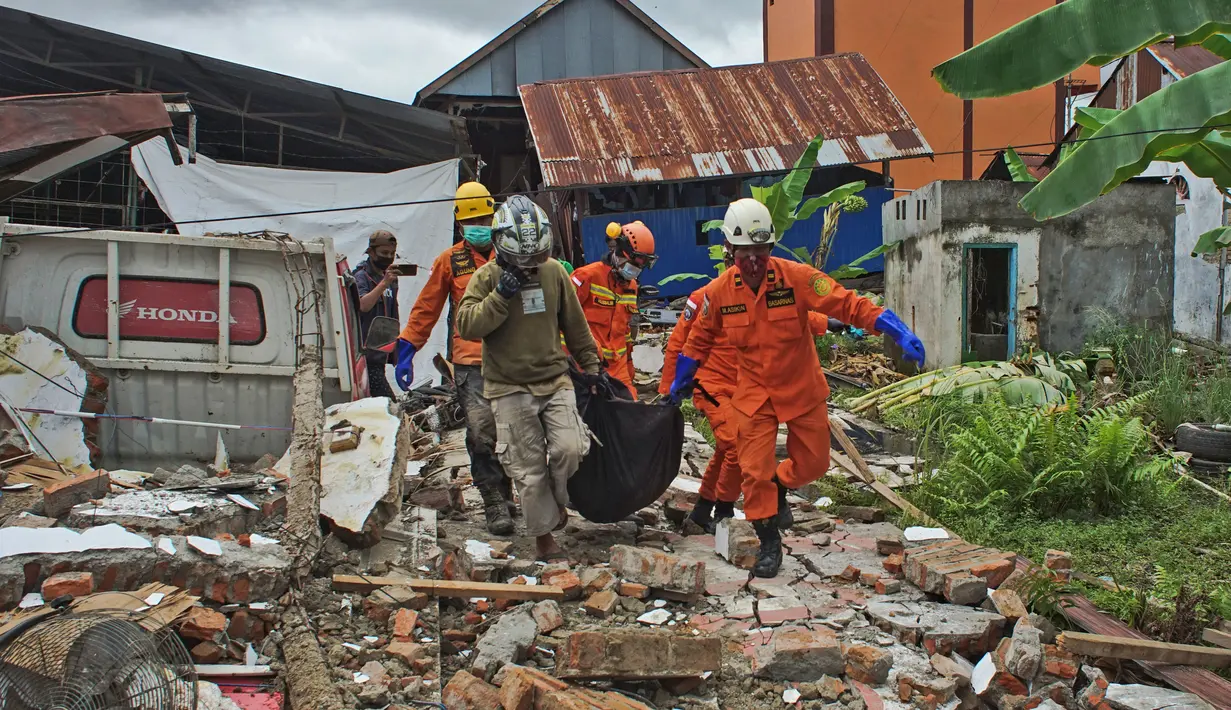 Tim penyelamat membawa kantong mayat berisi korban gempa bumi di Mamuju, Sulawesi Barat, Jumat (15/1/2021). Korban meninggal dikhawatirkan akan terus bertambah, karena beberapa laporan menyebutkan kemungkinan ada korban yang masih terjebak di bawah reruntuhan. (AP Photo/Azhari Surahman)