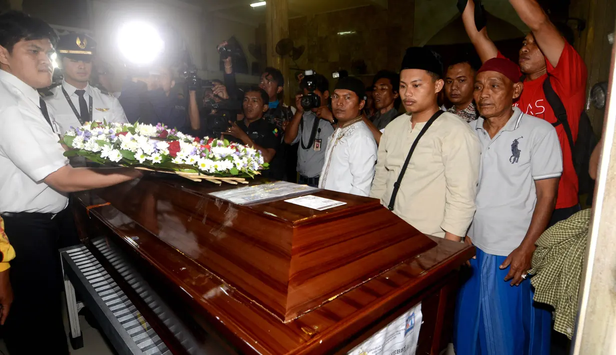 Petugas meletakkan bunga di atas peti jenazah Yudhistira Febbi Arianto, co pilot pesawat Aviastar yang tiba di masjid dekat Bandara Ngurah rai, Bali, Kamis (8/10). Pesawat Aviastar jatuh dan menewaskan 3 kru dan 7 penumpang. (AFP PHOTO/SONNY TUMBELAKA)