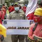 Petugas Satpol PP memegang poster imbauan protokol kesehatan COVID-19 saat unjuk rasa buruh di depan Gedung DPR, Jakarta, Selasa (17/11/2020). Pemerintah terus mengingatkan pentingnya 3M yaitu memakai masker, menjaga jarak, dan mencuci sebagai upaya pencegahan Covid-19. (Liputan6.com/Faizal Fanani)