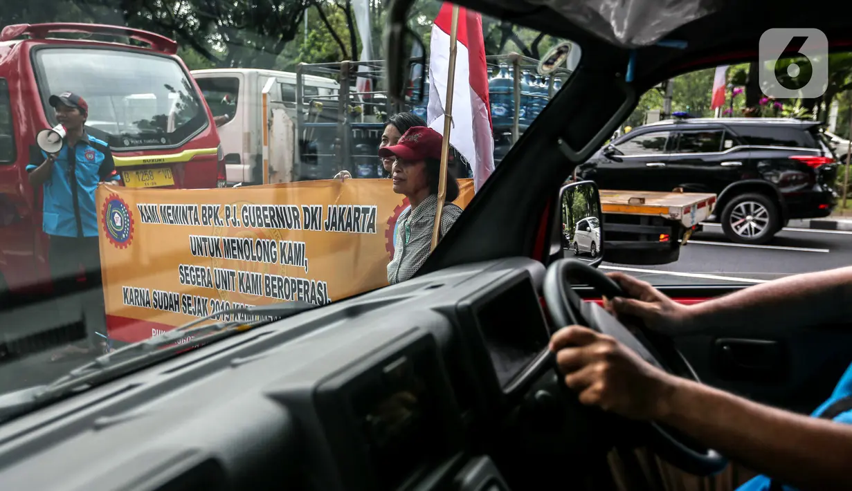Sejumlah sopir angkot Koperasi Wahana Kalpika (KWK) berorasi saat menggelar aksi di Balai Kota DKI Jakarta, Rabu (2/8/2023). (Liputan6.com/Faizal Fanani)