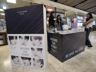 Sejumlah perempuan melihat salinan memoar BTS berjudul "Beyond the Story: 10-Year Record of BTS" yang dipajang untuk memperingati 10 tahun debut mereka di toko buku di Seoul, Korea Selatan, Minggu (9/7/2023). (AP Photo/Ahn Young-joon)