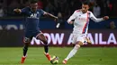 Bek Paris Saint-Germain (PSG), Nuno Mendes (kiri) ditantang oleh bek Olympique Lyon, Malo Gusto pada laga pekan keenam Liga Prancis di Stadion Parc des Princes, Senin (20/9/2021) dini hari WIB. PSG menang dengan skor tipis 2-1. (FRANCK FIFE / AFP)