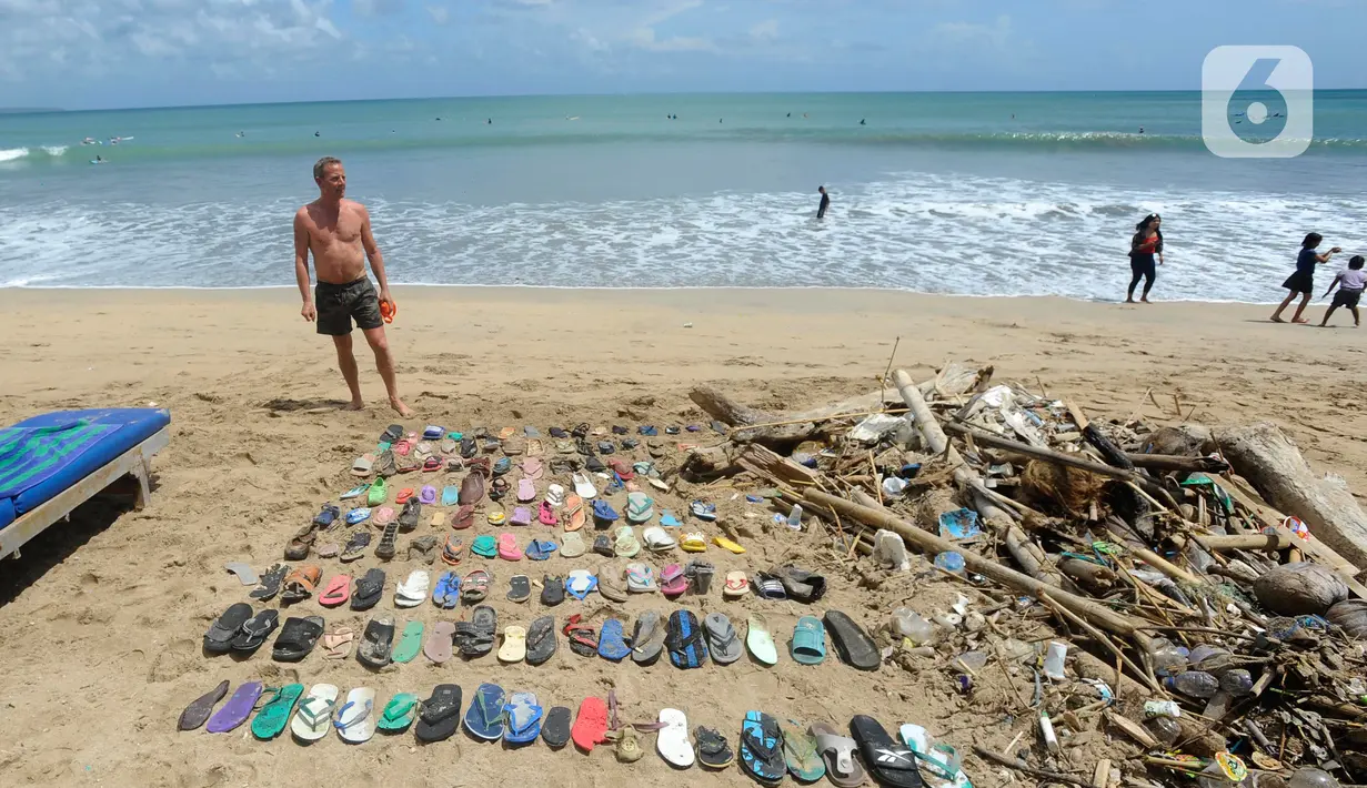 <p>Wisatawan asal Belanda menata sampah sandal dan sepatu yang dia kumpulkan dari Pantai Kuta. (merdeka.com/Arie Basuki)</p>