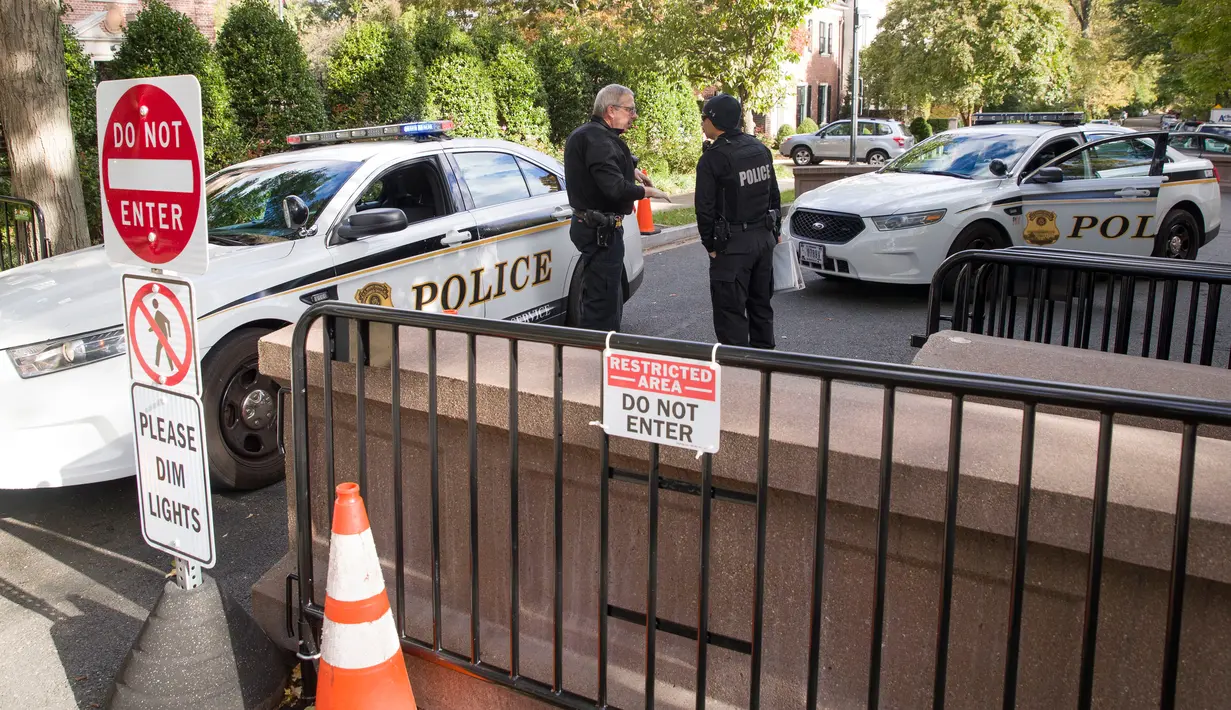 Petugas Secret Service berbincang di pos pemeriksaan dekat rumah mantan Presiden AS, Barack Obama di Washington, Rabu (24/10). Dinas Rahasia AS telah menggagalkan pengiriman paket berisi bahan peledak ke rumah Barack Obama. (AP /Alex Brandon)