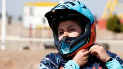 Behnaz Shafiei mengenakan helm jelang latihan di Parand, Teheran (27/2). Shafiei menjadi simbol kebebasan perempuan di Iran yang merupakan salah satu negara yang melarang kaum hawa berkendara di jalan umum. (AFP PHOTO/Atta Kenare)