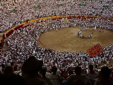 Orang-orang berkumpul di arena adu banteng pada hari terakhir Festival San Fermin di Pamplona, Spanyol, 14 Juli 2022. Ribuan orang dari seluruh dunia berduyun-duyun ke Pamplona selama sembilan hari setiap tahun untuk bersuka ria dalam pesta tanpa henti pada festival adu banteng yang ditangguhkan selama dua tahun terakhir karena pandemi virus corona COVID-19. (AP Photo/Alvaro Barrientos)