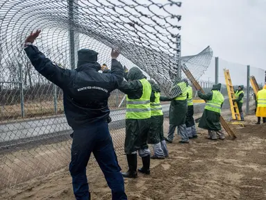 Narapidana mulai memasang pagar kedua di perbatasan Hungaria - Serbia, dekat Kelebia, 1 Maret 2017. Pagar perbatasan itu dilengkapi alat kejut listrik, sensor panas, kamera dan pengeras suara untuk mengusir para imigran. (Sandor Ujvari/MTI via AP)
