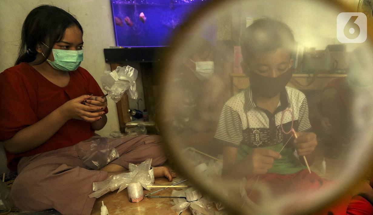 Anak-anak membuat serokan ikan cupang di rumah kontrakan Udin, Sukabumi Selatan, Jakarta Barat, Selasa (22/12/2020). Udin mengajak anak-anak warga sekitar rumahnya untuk ikut membantu pembuatan serokan ikan cupang. (Liputan6.com/Johan Tallo)