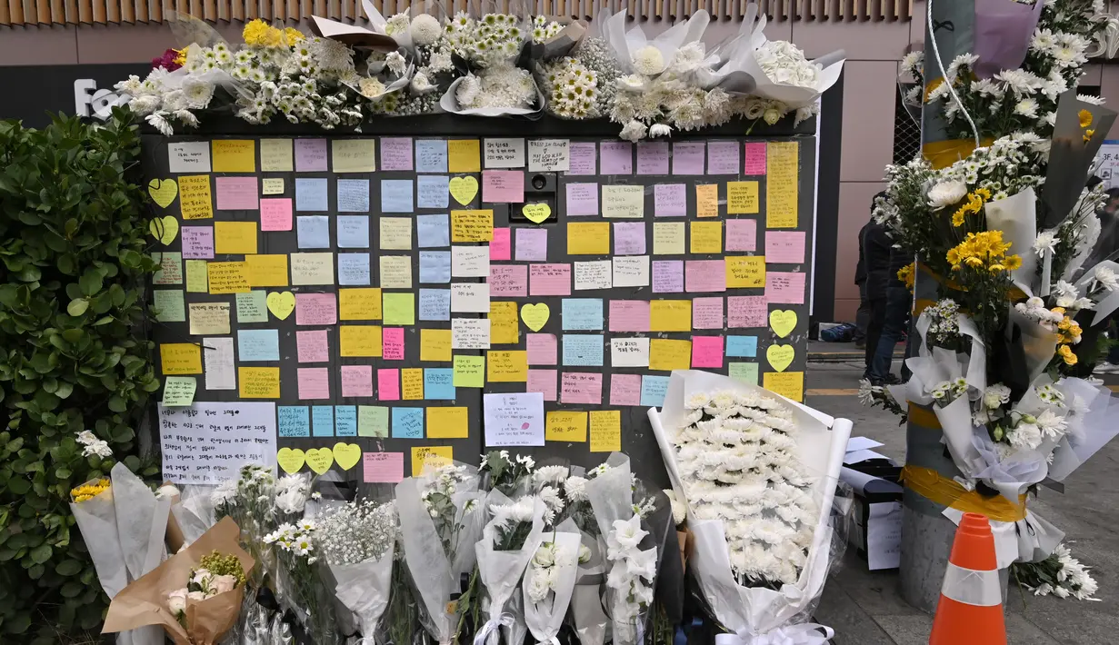 Bunga dan pesan dari pelayat terlihat di peringatan darurat untuk para korban akibat kerumunan massa dalam tragedi Halloween yang mematikan, di luar stasiun kereta bawah tanah di distrik Itaewon di Seoul, Kamis (3/11/2022). Banyak masyarakat nasional maupun internasional yang bergabung dalam masa berkabung nasional dan memperingati semua nyawa yang hilang dalam Tragedi Halloween Itaewon. (Jung Yeon-je / AFP)