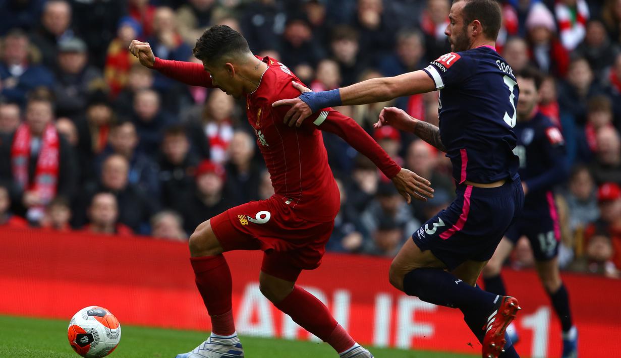 Gelandang Liverpool, Roberto Firmino, berebut bola dengan pemain Bournemouth pada laga lanjutan Premier League 2019-2020 di Anfield, Liverpool, Sabtu (7/3) malam WIB. Liverpool menang 2-1 atas Bournemouth. (AFP/Geoff Caddick)