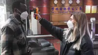 Verdi Olha dari Ukraina mengukur suhu tubuh pelajar lain di Universitas Chongqing di Chongqing, China, 18 Februari 2020. Sejumlah pelajar asing di Chongqing ambil bagian dalam kampanye pengendalian epidemi dengan terlibat dalam pekerjaan sukarela. (Xinhua/Wang Quanchao)