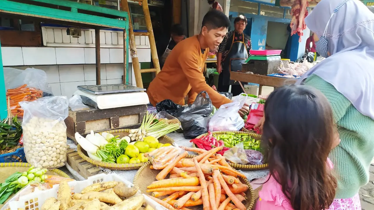 Seorang pedagang tengah melayani pembeli sayuran di salah satu lapak pasar kojengkang Suci, Karangpawitan, Garut, Jawa Barat.