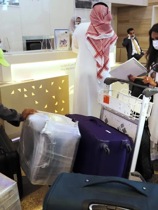 Hanan Yousef (35) memeriksa koper-kopernya untuk perjalanan wisata ke Mesir, di Bandara Internasional King Abdulaziz, Jeddah, Senin (177/5/2021). Warga Saudi yang telah menerima vaksinasi Covid-19 diizinkan bepergian ke luar negeri menyusul dicabutnya larangan perjalanan. (AP Photo/Amr Nabil)