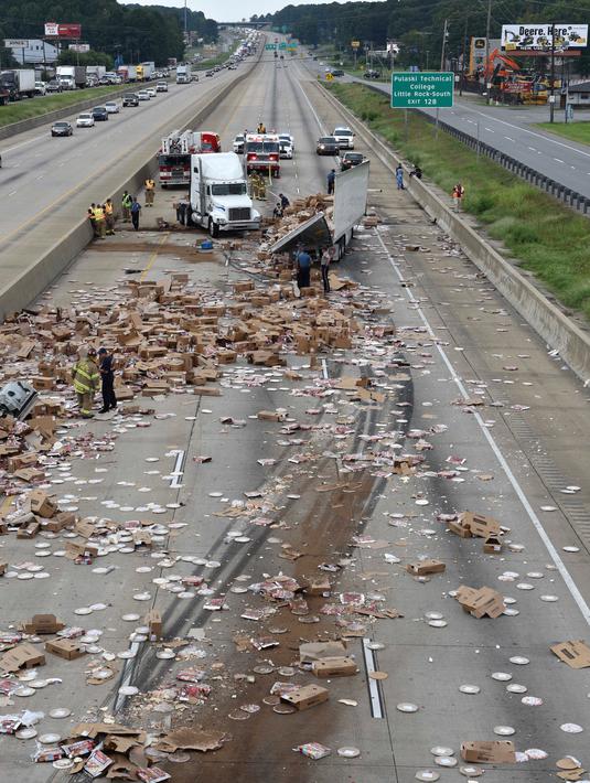 Sebuah truk pembawa pizza beku kehilangan kendali setelah melintasi jembatan di Jalan Raya Arkansas, Amerika Serikat, 9 Agustus 2017. Truk itu pun terbalik dan membuat pizza beku berserakan di jalanan. (Arkansas Department of Transportation via AP)