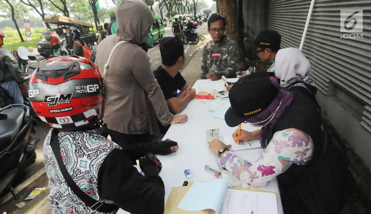 Anggota Satlantas Polres Tangerang Selatan memeriksa kelengkapan surat saat razia pajak kendaraan di Jalan BSD, Tangerang Selatan, Kamis (24/1). Razia ini untuk mendisiplinkan pengendara terhadap pembayaran pajak kendaran. (Merdeka.com/Arie Basuki)