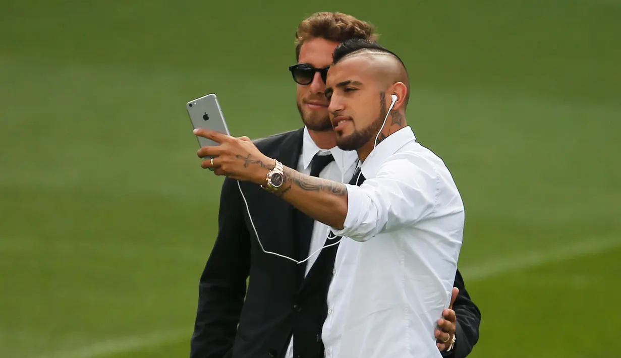 Gelandang Juventus,  Arturo Vidal (kanan) bersama Claudio Marchisio berselfie jelang konferensi pers di Stadion Santiago Bernabeu, Spanyol (12/5/2015). Juventus akan menantang Real Madrid di leg kedua semifinal Liga Champions.  (Reuters/Sergio Perez)