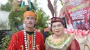 Pasangan pria dan wanita dengan pakaian adat Kalimantan Tengah berpose dalam rangkaian acara Festival Budaya Isen Mulang di Bundaran Palangkaraya, Minggu (19/5/24) pagi. (Bola.com/Ade Yusuf Satria)