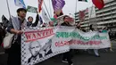 Warga yang menyatakan solidaritas terhadap Palestina melintas di depan Kedutaan Besar Amerika Serikat saat mengikuti aksi yang mengecam tindakan militer AS dan Israel di Gaza, di Seoul, Korea Selatan, Sabtu (3/10/2026). Para peserta membawa sejumlah atribut dukungan terhadap Palestina sambil berjalan melewati kawasan pusat kota. Aksi tersebut merupakan bagian dari rangkaian unjuk rasa yang menyuarakan perhatian terhadap situasi di Gaza. (AP Photo/Ahn Young-joon)
