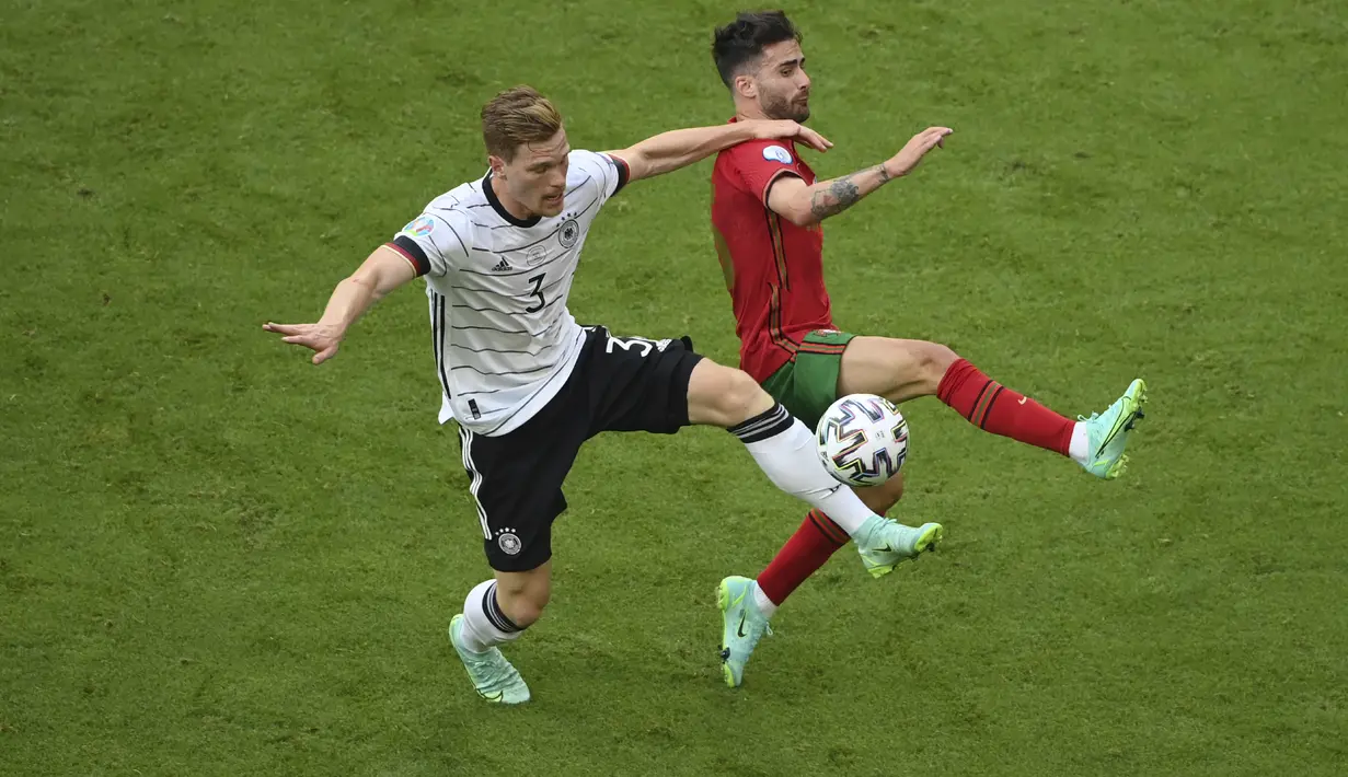 Bek Jerman, Marcel Halstenberg (kiri) berebut bola dengan pemain Portugal, Rafa Silva pada pertandingan grup F Euro 2020  di Allianz Arena, Munich, Sabtu (19/6/2021). Jerman menang telak atas Portugal dengan skor 4-2.  (Matthias Hangst/Pool Photo via AP)