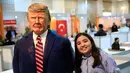 Seorang anak berpose dengan patung Presiden AS Donald Trump yang terbuat dari cokelat dalam Festival Cokelat Turki di museum militer Istanbul, 25 Maret 2017.Karya seni lezat itu dibuat oleh chef perempuan Turki, Tuba Geckil. (AP Photo/Lefteris Pitarakis)