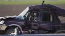 Petugas memilah bukti dan puing-puing di lokasi kecelakaan mematikan truk yang menabrak mobil SUV di Holtville, California (2/3/2021). Sopir truk gandeng itu kini dirawat karena cedera ringan. (AP Photo/Gregory Bull)