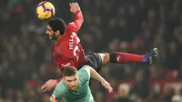 Gelandang Manchester United, Marouane Fellaini, duel udara dengan bek Arsenal, Shkodran Mustafi pada laga Premier League di Stadion Old Trafford, Manchester, Rabu (5/12). Kedua klub bermain imbang 2-2. (AFP/Oli Scarff)