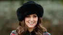 Kate Middleton menggenggam buket bunga usai tradisi kebaktian Hari Natal Kerajaan Inggris di Gereja St. Mary Magdalene, Sandringham, Senin (25/12). Kate membiarkan rambut coklatnya tergerai dan riasan wajah natural dengan lipstik nude. (AP/Alastair Grant)