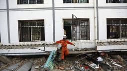 Salah satu anggota tim penyelamat keluar dari gedung yang rusak akibat gempa di Longtoushan, provinsi Yunan, Tiongkok, (6/8/2014). (REUTERS/Stringer)