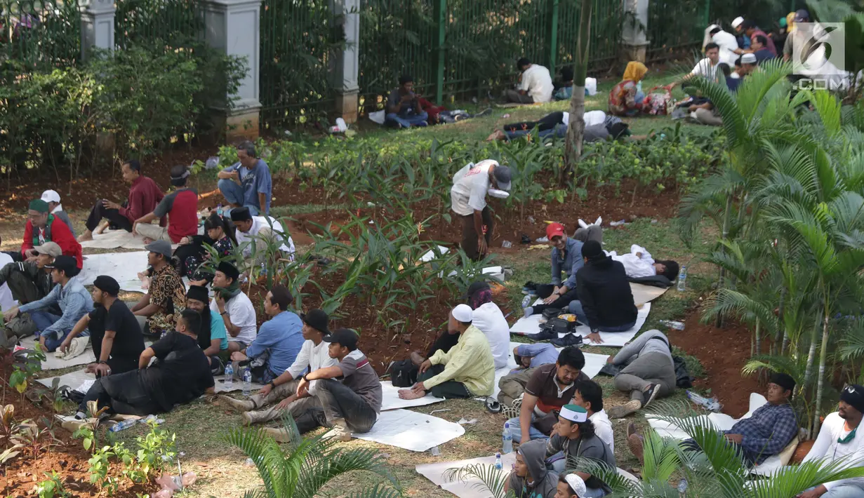 Massa aksi duduk-duduk beristirahat di taman kawasan silang Monas di Jalan Medan Merdeka Barat, Jakarta, Kamis (27/6/2019). Massa aksi berkumpul terkait pelaksanaan sidang putusan perselisihan hasil Pilpres 2019 di Gedung Mahkamah Konstitusi. (Liputan6.com/Helmi Fithriansyah)