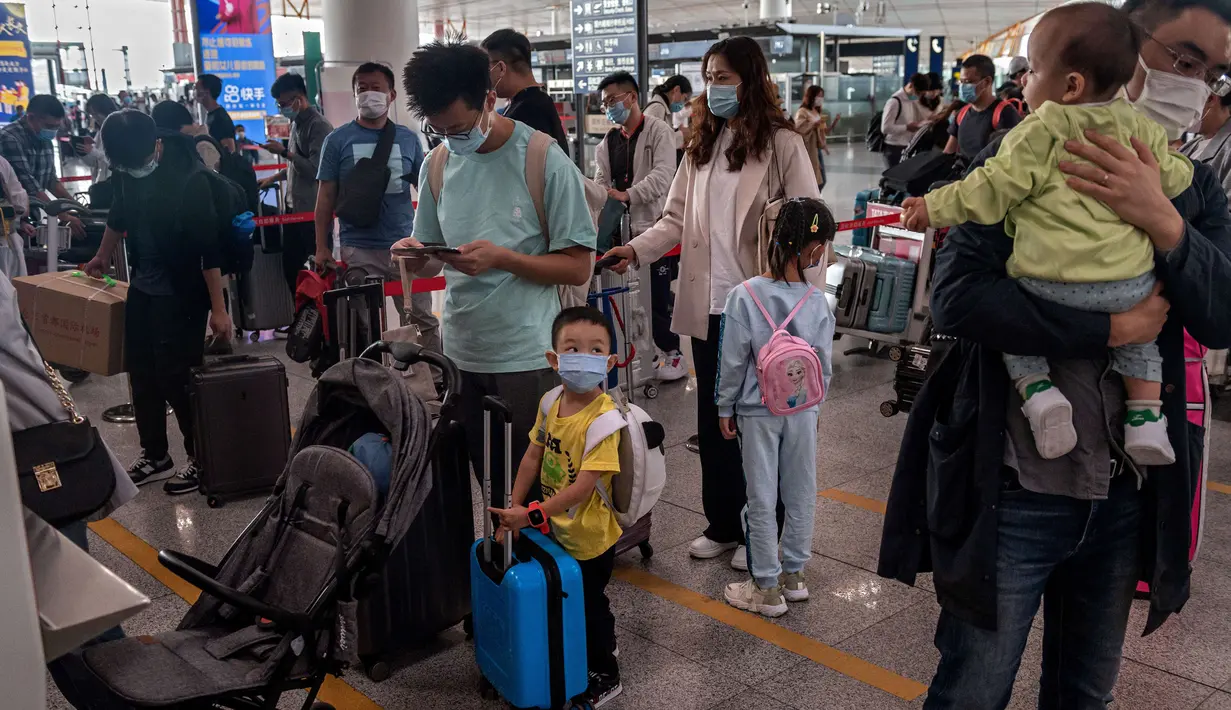 Orang-orang mengantre check-in untuk penerbangan domestik menjelang liburan "Golden Week" di Bandara Internasional Ibu Kota Beijing pada 30 September 2020. Gelombang liburan melanda China yang warganya merayakan libur panjang, yang dikenal dengan Golden Week. (NICOLAS ASFOURI / AFP)