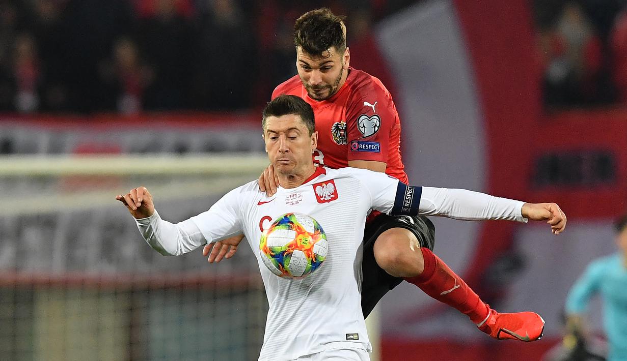 Striker Polandia, Robert Lewandowski (depan) menguasai bola dari gangguan bek Austria, Aleksandar Dragovic pada laga Grup B Kualifikasi Piala Eropa 2020 di Vienna, Austria (21/3/2019). Robert Lewandowski hingga kini telah mengoleksi 19 gol dan 7 assist dari 20 laga pada babak kualifikasi Piala Eropa serta mampu membawa Timnas Polandia selalu lolos dalam 3 edisi terakhir putaran final Piala Eropa mulai 2012 hingga 2020. (AFP/Joe Klamar)