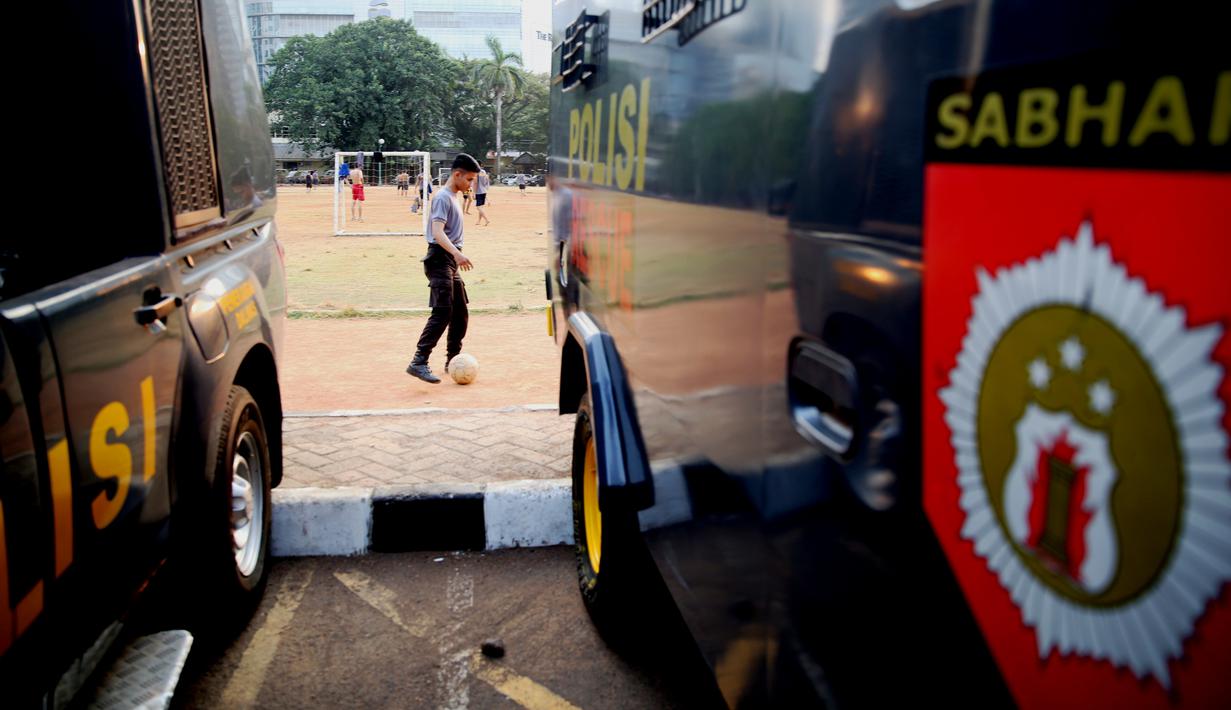 Polisi dari kesatuan Sabhara merenggangkan otot dengan bermain bola di Kawasan Polda Metro, Jakarta, Selasa (13/10/2015). Pihak Kepolisian dan TNI bersiap siaga menjelang laga Final Piala Presiden 2015. (Bola.com/Nicklas Hanoatubun).