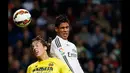 Bek Real Madrid, Raphael Varane (kanan) berebut bola di udara dengan gelandang Villarreal Tomas Pina pada laga Liga Spanyol di Santiago Bernabeu, Spanyol, (1/3/2015). Real Madrid bermain imbang dengan Villareal (1-1).  (Reuters/Susana Vera)