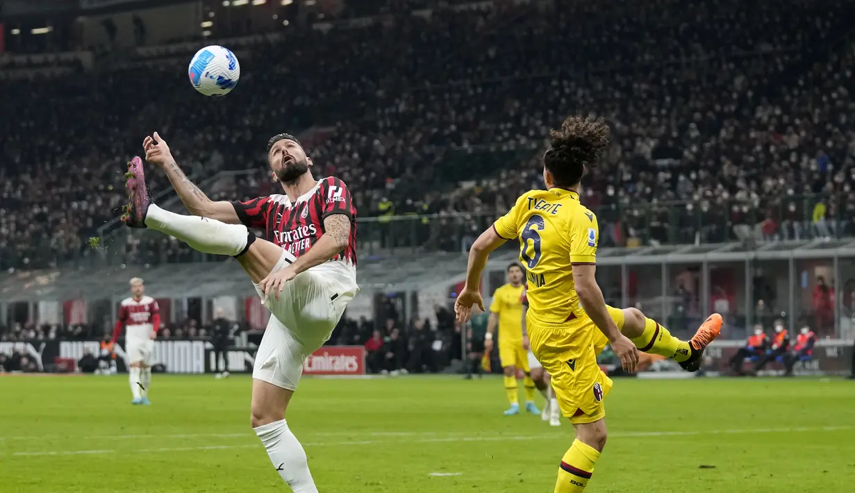Penyerang AC Milan, Olivier Giroud mengontrol bola dari kawalan pemain Bologna, Arthur Theate pada pertandingan Liga Serie A Italia di stadion San Siro, Italia (5/4/2022). Tambahan satu angka membuat Milan mempertahankan posisi puncak dengan koleksi 67 angka dari 31 laga. (AP Photo/Antonio Calanni)