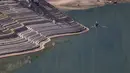 Garis air terlihat di tepi curam Danau Oroville saat seorang nelayan mengapung di Oroville, California (1/6/2021). Volume air waduk Danau Oroville yang terus menyusut saat ini menyisakan kapasitas 38 persen. (AFP/Justin Sullivan)