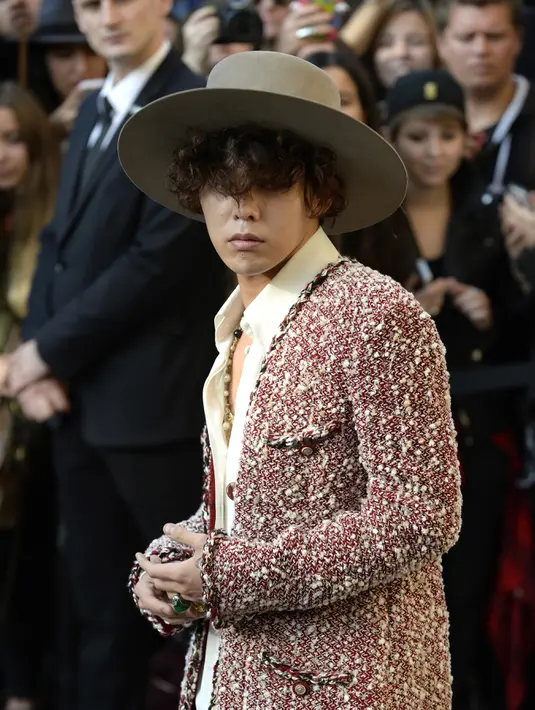 G-Dragon mengubah gaya rambutnya menjadi keriting. Menghadiri presentasi ‘Spring/Summer 2015 Ready to Wear Collection’ di Paris yang dingin membuat G-Dragon memakai blazer wool untuk menghangatkan tubuhnya. (Bintang/EPA)